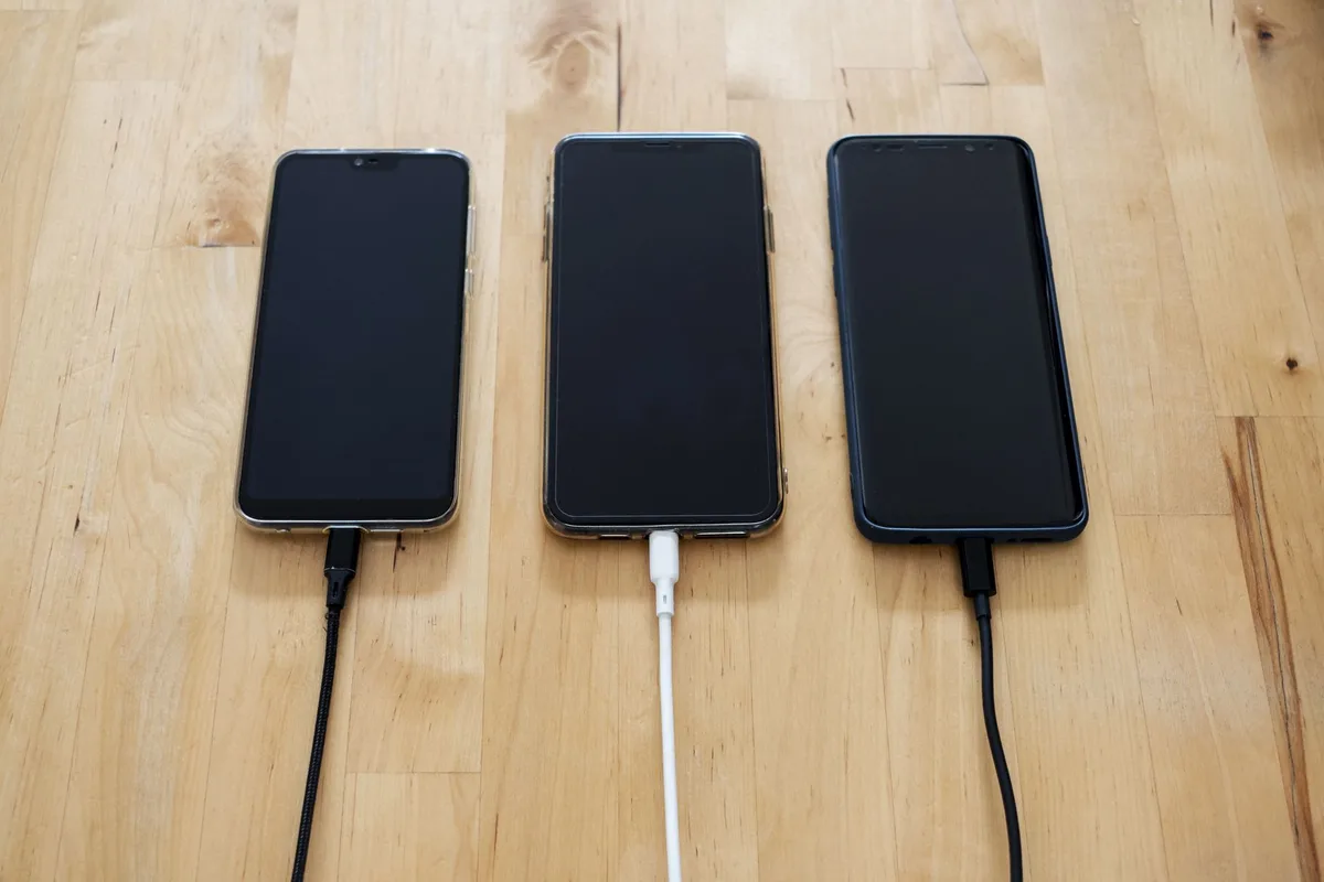 Smartphone auf Tisch mit W&auml;rmewellen, Sonne im Hintergrund