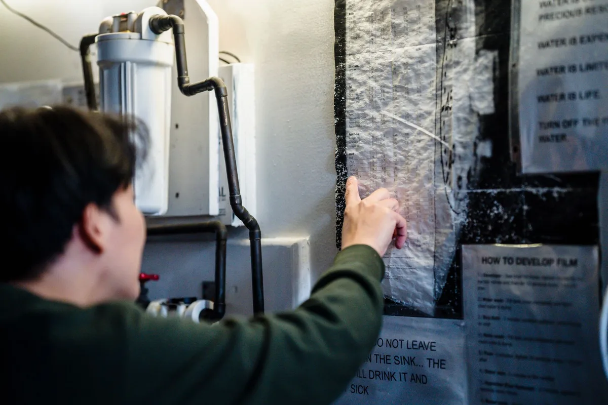 Teilnehmer in einem Fotografie-Workshop arbeiten gemeinsam an Dunkelkammertechniken