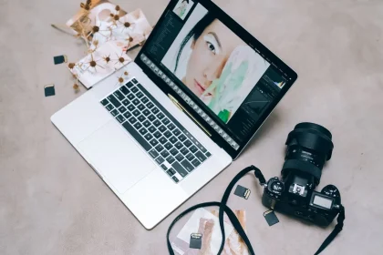 Fotograf sitzt am Laptop und bearbeitet Aufnahmen in einem dunklen Studio