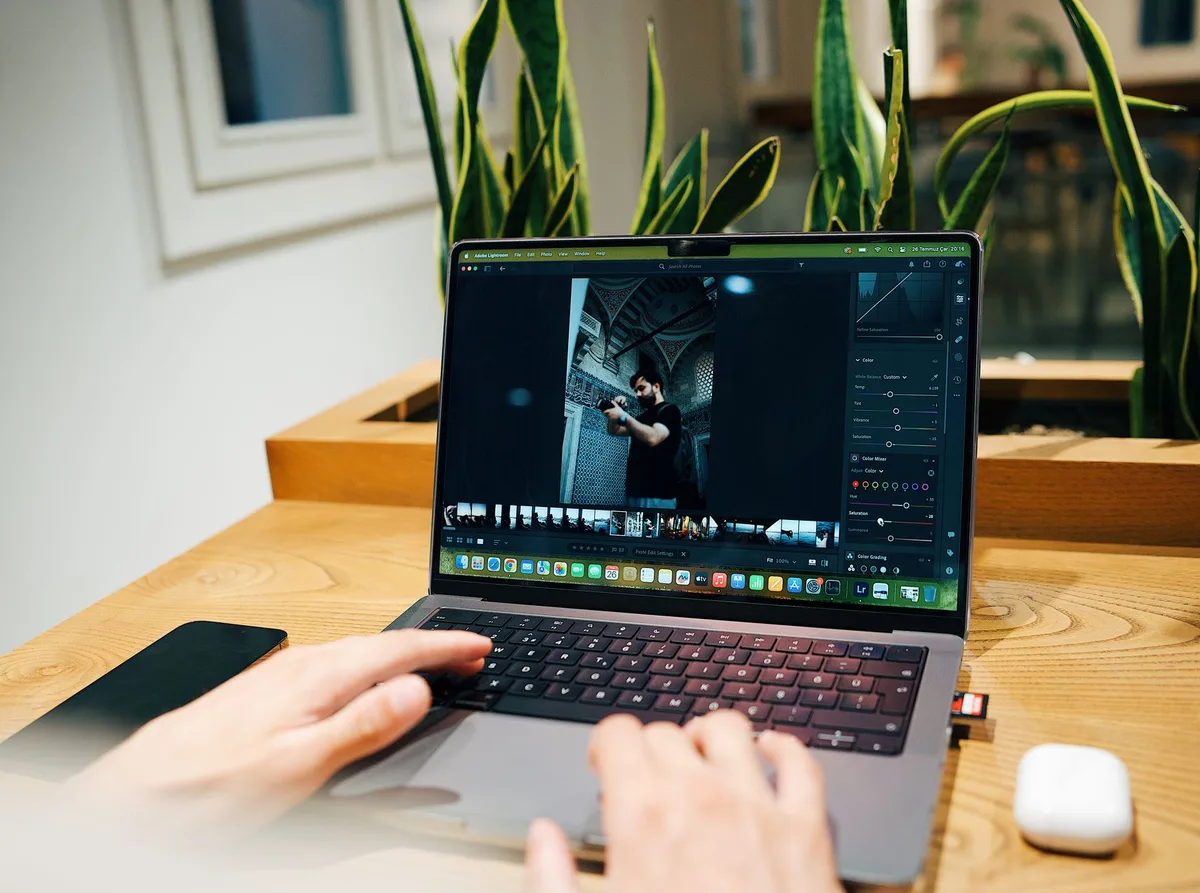 Fotograf arbeitet mit RAW-Dateien und Bearbeitungssoftware an einem Computer