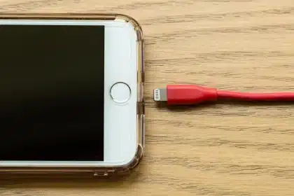 Kompakte Powerbank mit integriertem USB-C-Kabel neben Smartphone und Reiseutensilien