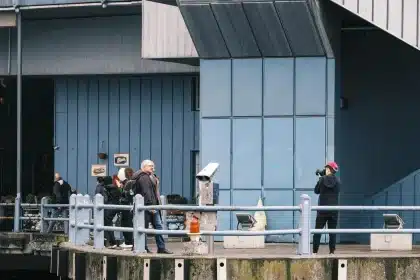 Fotograf mit Kamera auf belebter Straße, Menschen und städtische Umgebung im Hintergrund
