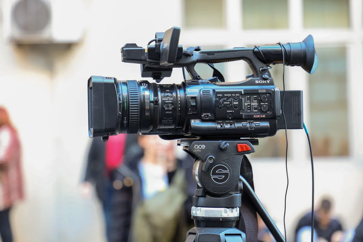 Videograf mit Kamera und Objektiv bei der Aufnahme
