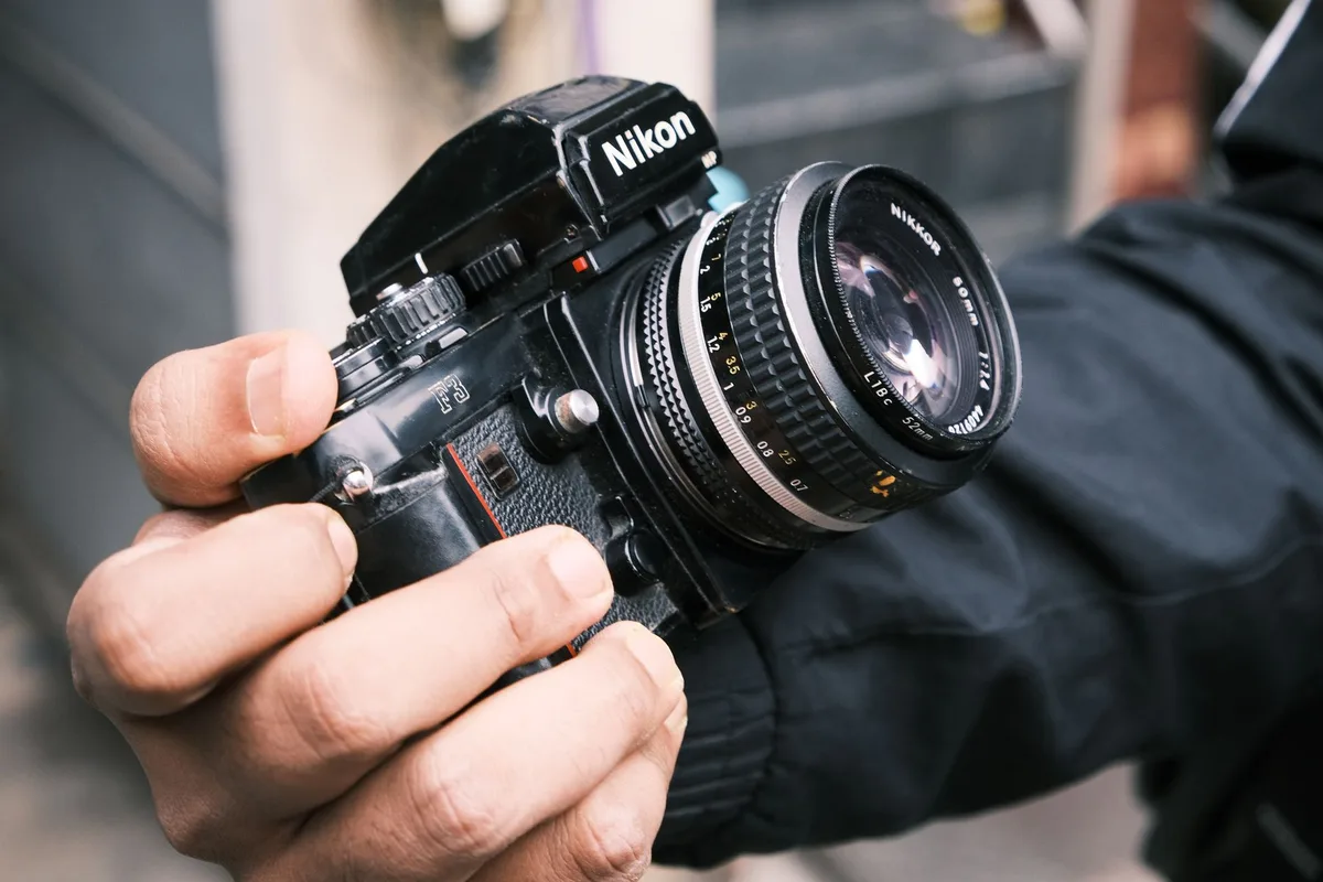 Fotografin mit Kleinbildkamera bei der Reportagefotografie in urbaner Umgebung