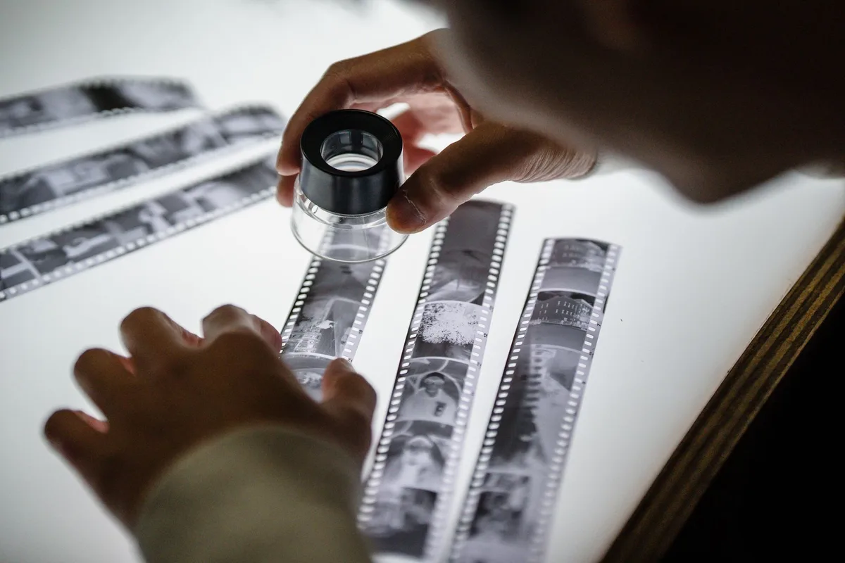 Verschiedene Filmrollen und Kontaktabzüge auf einem Arbeitstisch
