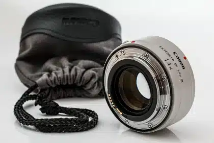 Fotograf hält ein Ultraweitwinkel-Zoomobjektiv mit stark gewölbter Frontlinse in der Hand