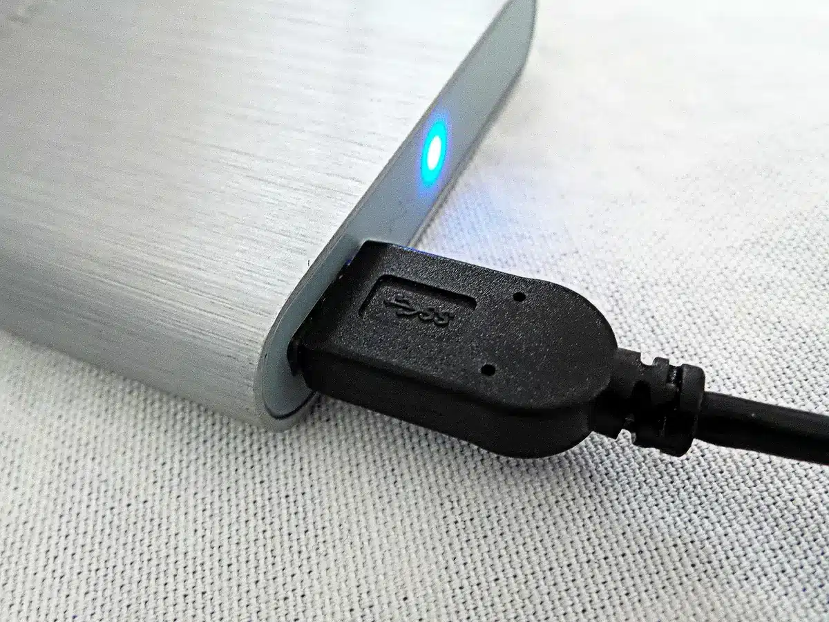 Externe Festplatte neben einem Laptop zur Datensicherung