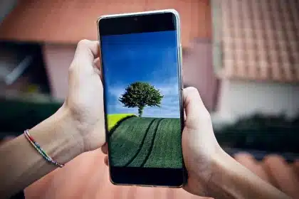 Person mit Smartphone prüft Navigationsanweisungen an einer Straßenkreuzung