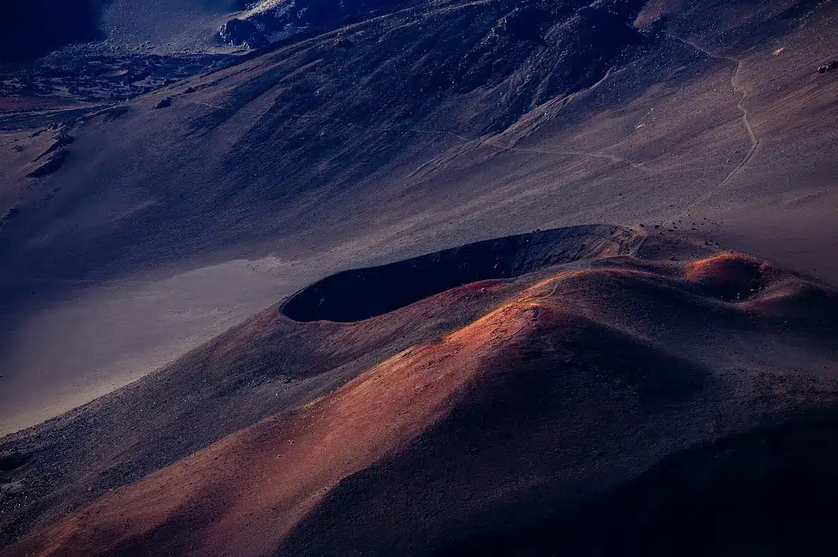 Dichter Lavafluss in weiter Landschaft, fotografisch als Lichtspur dargestellt