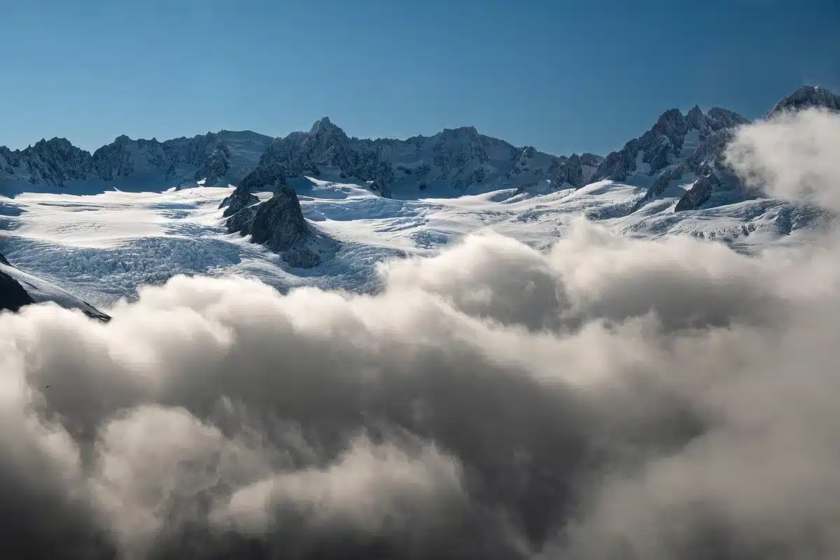 Eisstücke auf schwarzem Strand vor Gletscherlagune bei weichem Licht