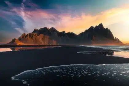 Stativ und Filter auf schwarzem Sand mit entfernten Lavafeldern im Licht