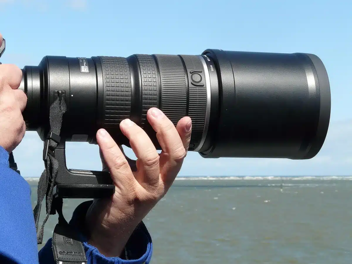 Fotograf mit stabilem Stativ auf windigem Lavagel&auml;nde, Ausr&uuml;stung gesichert