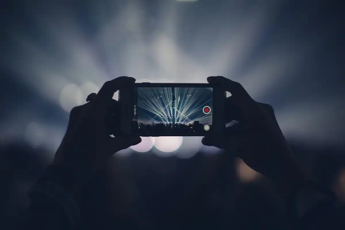 Person markiert Drehorte und Notizen auf Smartphone und Notizblock