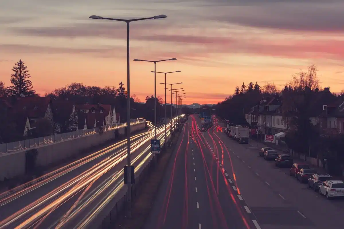 Fotograf mit kompaktem LED-Licht bei Dämmerung auf einer Straßenszene