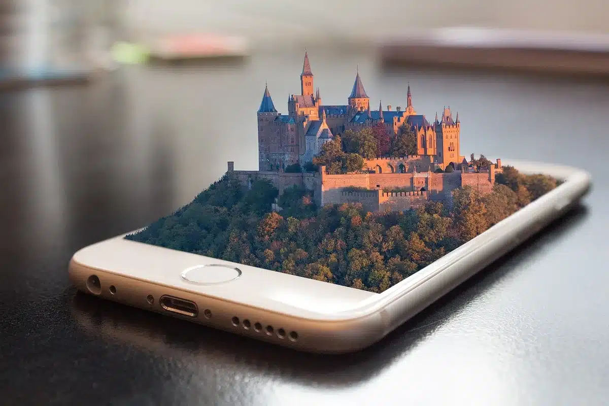 Smartphone neben kompakter Gimbal-Kamera auf einem Holztisch bei Tageslicht