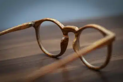Fotograf hält ein Tele-Makroobjektiv auf einem Tisch, Nahaufnahme ohne Marken