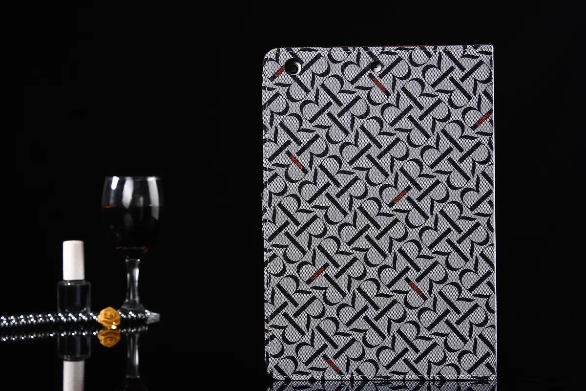 Silhouette von Händen am iPhone neben lederhülle und kleinem silbernem Griff auf Holztisch