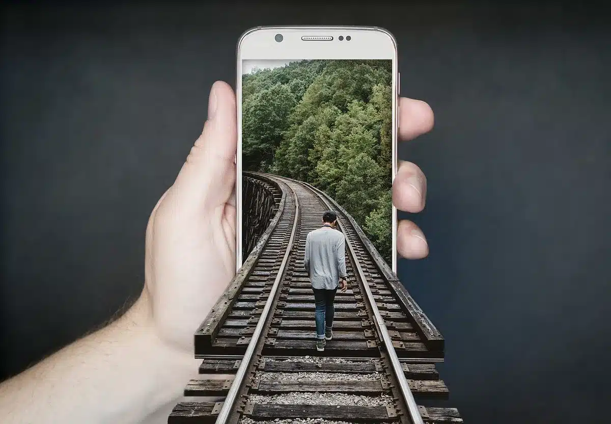 Smartphone auf kleinem Stativ vor einer Blüte für Makroaufnahmen