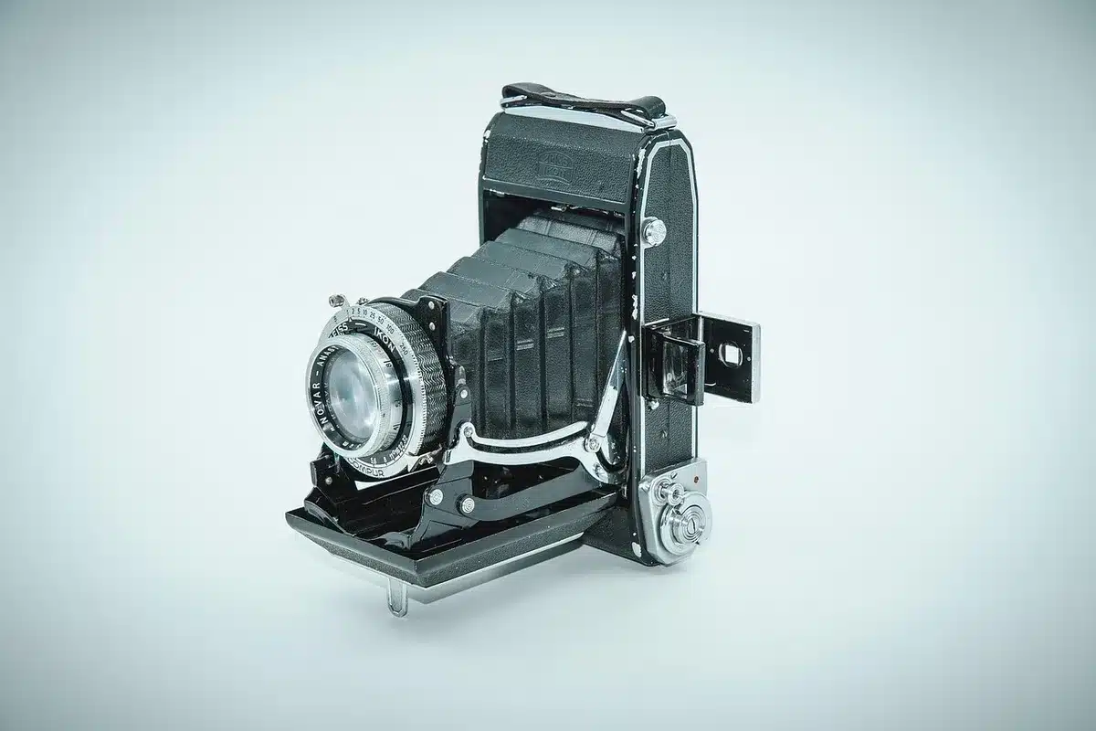 Gefrästes Metallgehäuse eines Objektivs neben einer Fuji-Kamera auf Reisen