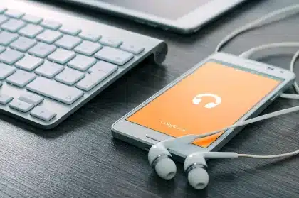 Anonymisierte Person hält Smartphone mit Einstellungen und Sprachliste, EU-Symbole unscharf